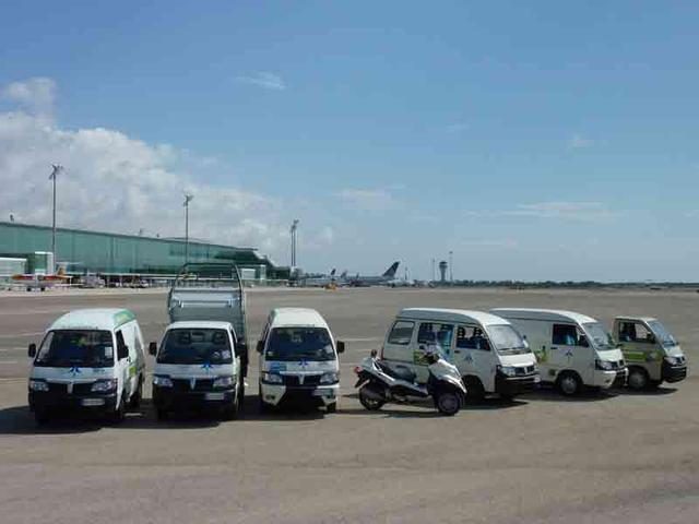 Los siete vehículos Piaggio delante de la Terminal 1 del Aeropuerto de Barcelona