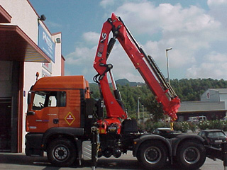 Una grúa de uso industrial Hiab instalada sobre una cabeza tractora de tres ejes.